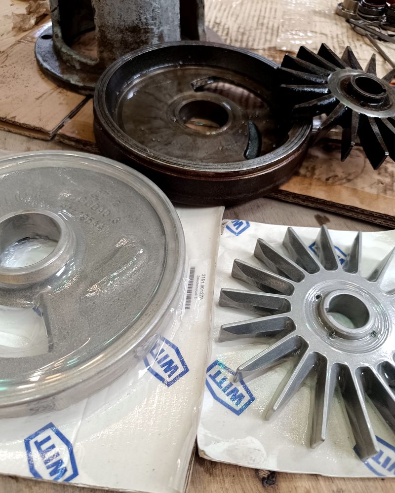 Pieza intermedia e impulsor nuevos junto a las piezas desmontadas